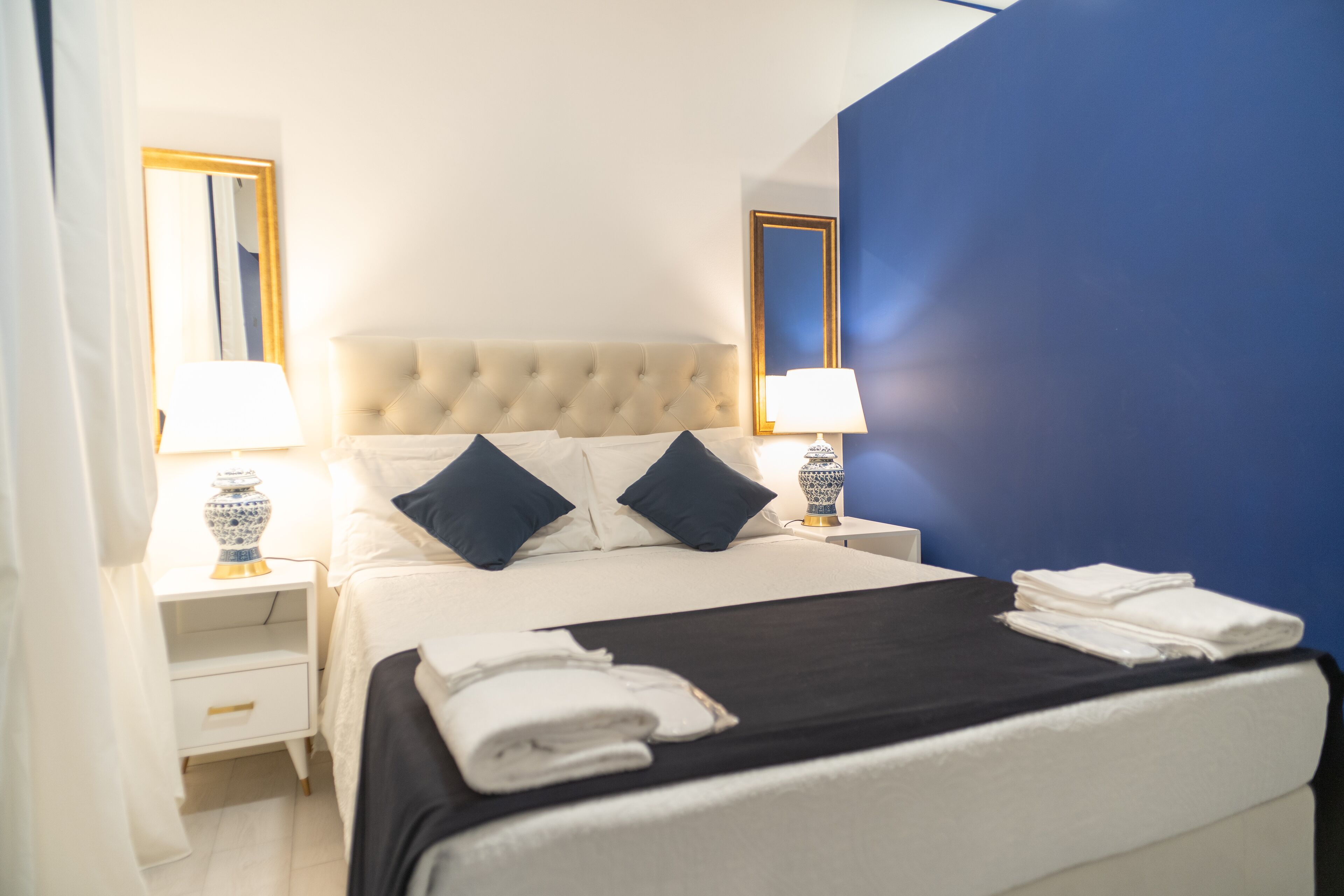A hotel room with a large bed, two bedside tables, and a nightstand.