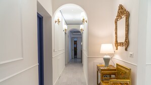 A hallway with a blue door, a lamp, and a mirror on the wall. - La Residenza di Michelangelo (Florence)