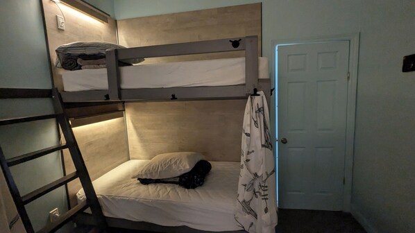 A bunk bed room with a ladder, a single bed, and a door. - Auberge Jeunesse LouLou's Backpacker Hostel (Levis)