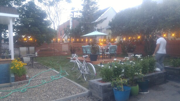 Un patio con mobiliario exterior, una bicicleta y plantas en macetas.