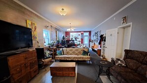 Una sala de estar con televisión, sofás, una mesa de centro y un árbol de Navidad.