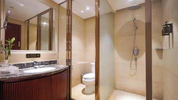 Un baño moderno con ducha de vidrio, lavabo de mármol y retrete.