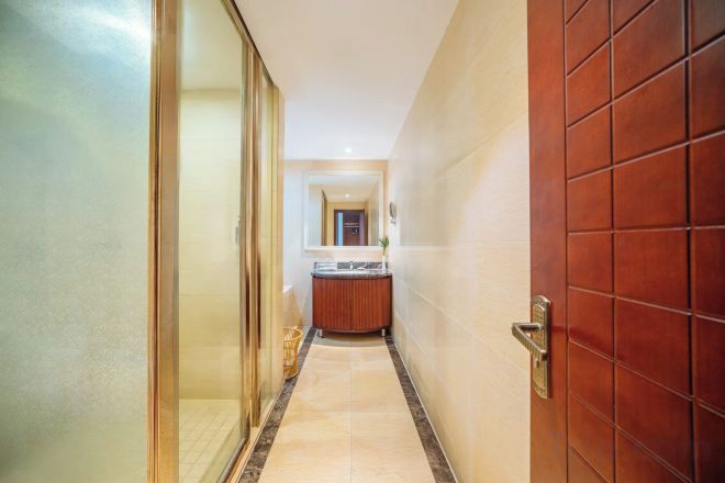 A hallway with a glass door on the left and a wooden door on the right.