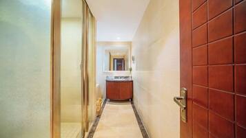 A hallway with a glass door on the left and a wooden door on the right.