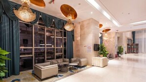 Un hall d’entrée spacieux, doté d’un coin salon, de grandes fenêtres et d’un lustre.