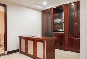 Una habitación moderna con un escritorio y armarios de madera, un inodoro y un lavabo.