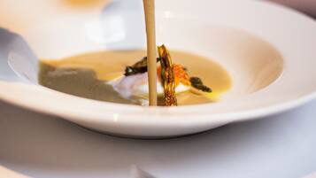 Un plato blanco con sopa y una cuchara.