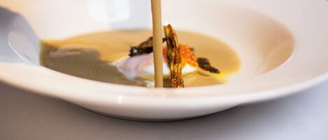 A white plate with a soup and a spoon.