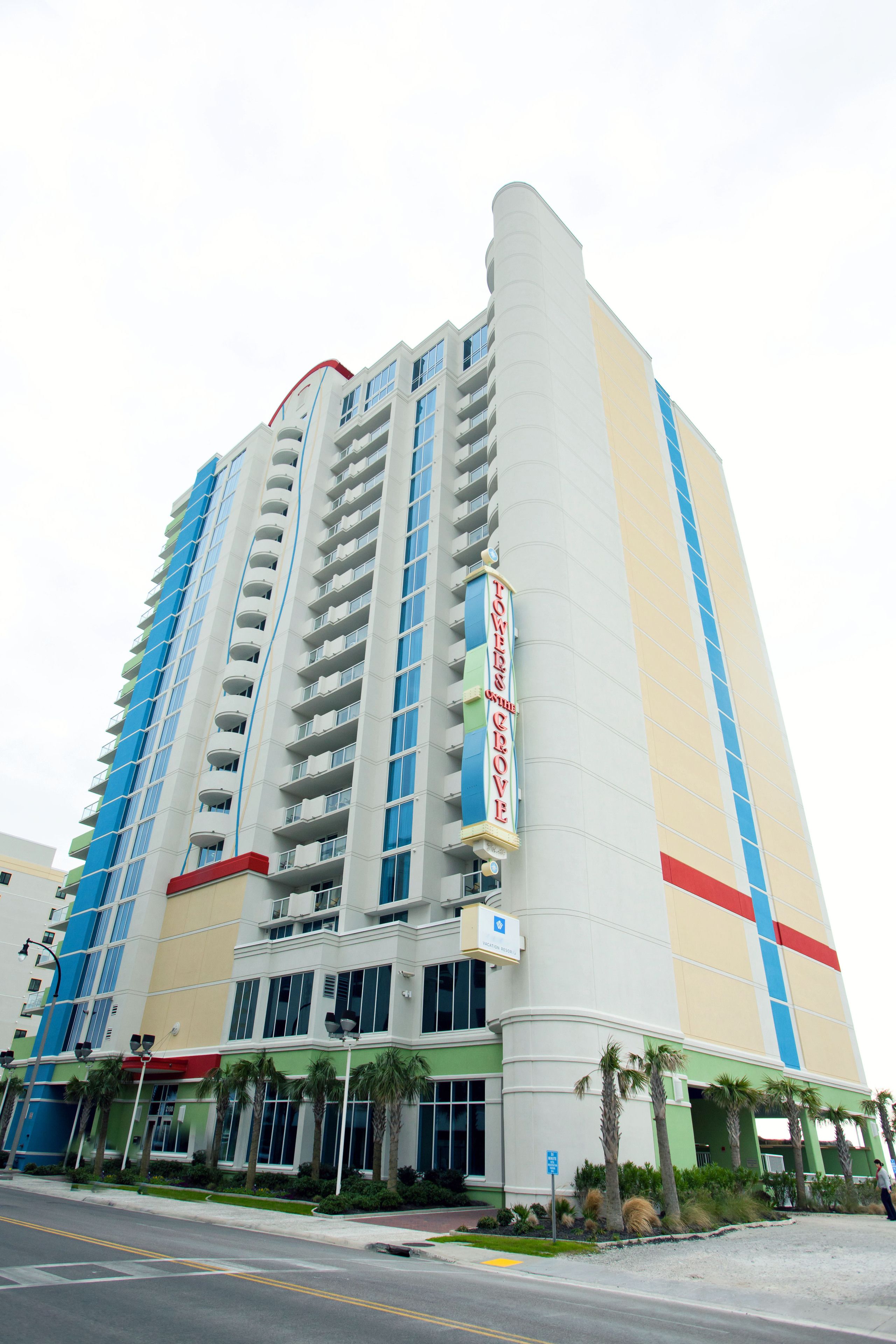 A tall hotel with multiple floors, balconies, and a prominent sign.