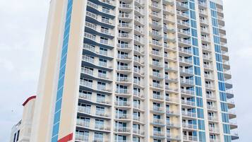 A tall, multi-story hotel with a modern design, featuring balconies on each floor.