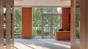 A modern reception area with a glass door leading to an outdoor garden. - LOTTE CITY HOTEL GURO (Seoul)