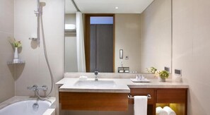 Une salle de bain moderne avec une baignoire, un lavabo et un miroir.