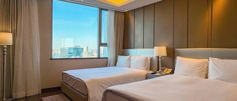 A hotel room with two beds, a city view, and a modern design.
