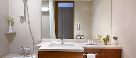 A modern bathroom with a bathtub, a vanity with a mirror, and a shower.