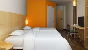 A hotel room with two beds, a desk with a chair, a television, and a door. - Ibis Changchun Jianshe Street (Changchun)