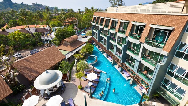 A hotel with a swimming pool, multiple balconies, and a view of the surrounding landscape. - Ramaburin Resort (Patong)