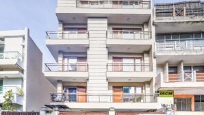 Un edificio de varios pisos con balcones, un letrero visible que dice 'IACM' y una entrada protegida por una reja.