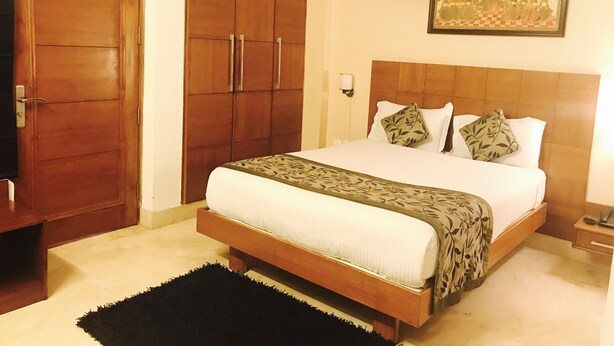 Un dormitorio con una cama grande, un armario de madera y un cuadro en la pared.