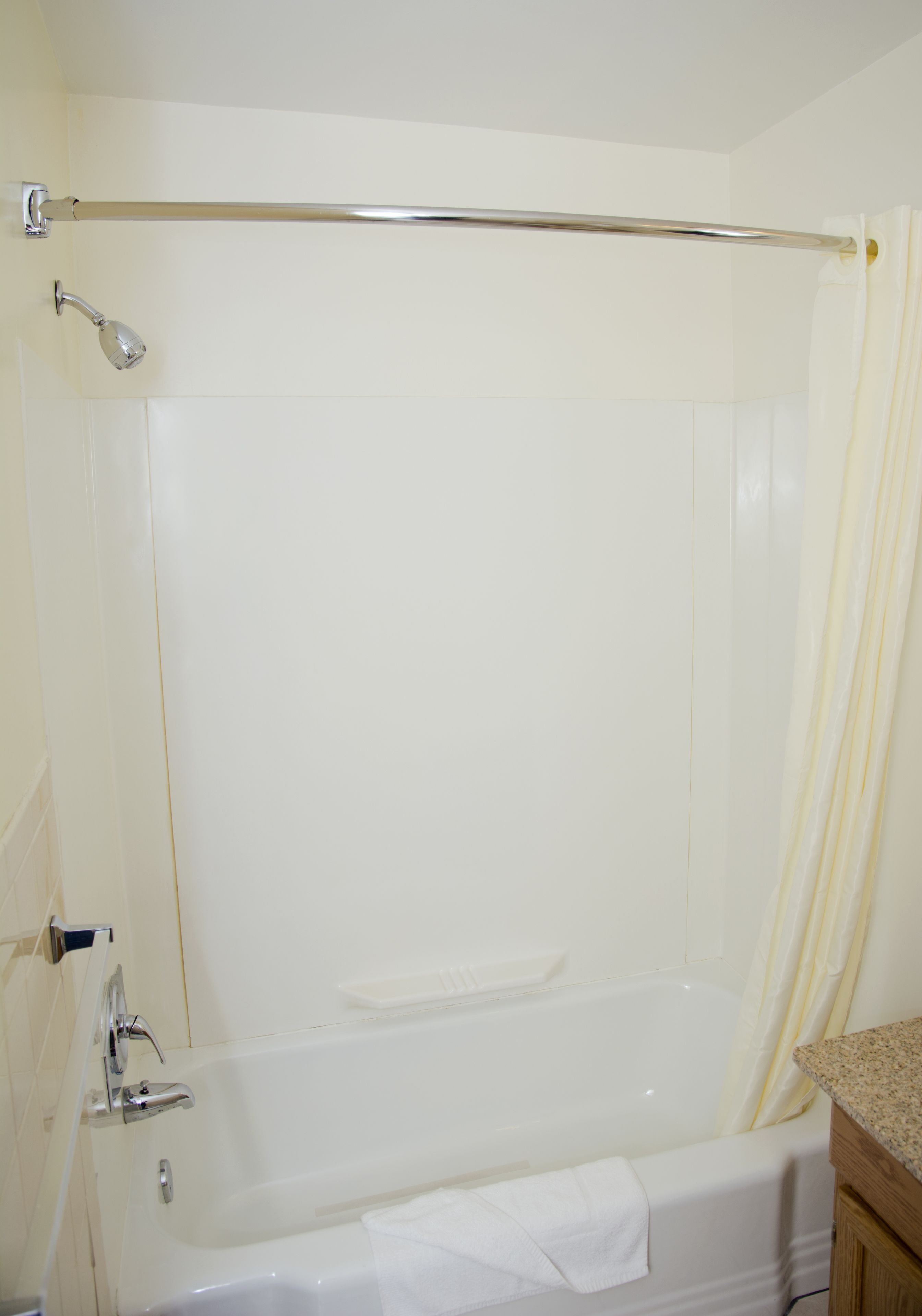 Un baño con bañera, cabezal de ducha y perchero para toallas.