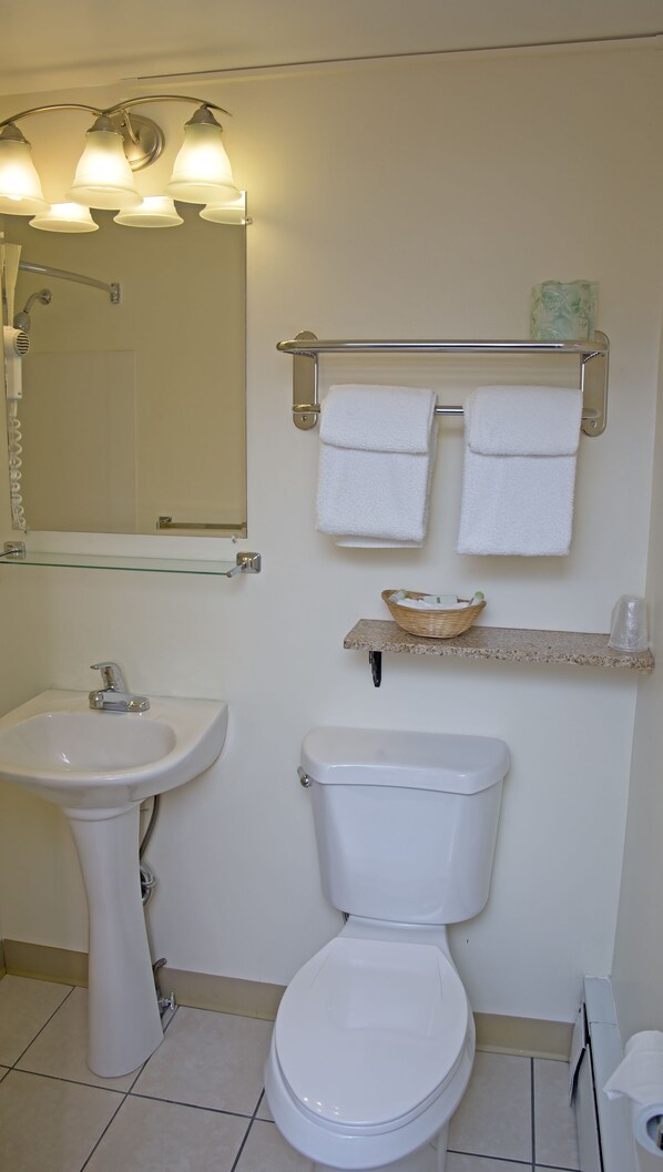 A bathroom with a sink, toilet, and a towel rack with two towels.
