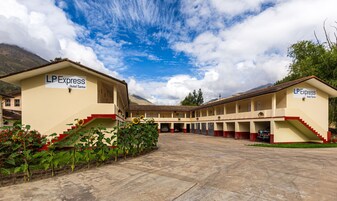 A hotel with a central courtyard, multiple guest rooms, and a sign indicating it is part of the LP Express Hotel Tarma chain.