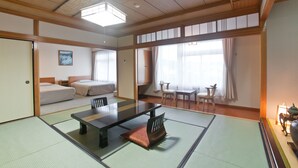Une pièce de style japonais traditionnel, avec un sol recouvert de tatamis, une petite table basse avec des coussins, un lit avec un futon et une porte coulissante.