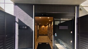 A hotel entrance with a black door, a reception desk, and a sign indicating the hotel's name.
