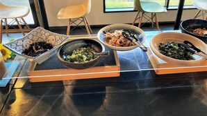 A dining area with a table set for a meal, featuring various dishes in bowls.