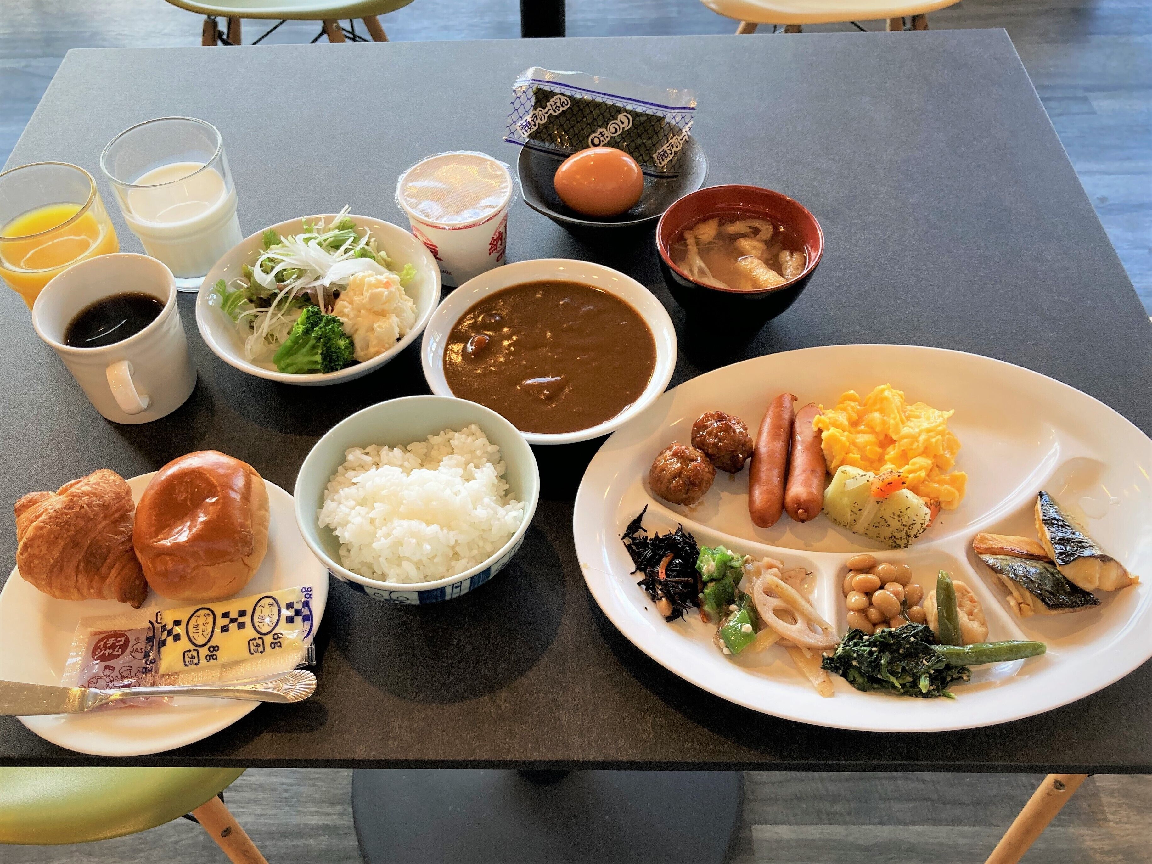 A table with various dishes including rice, sausages, and vegetables.