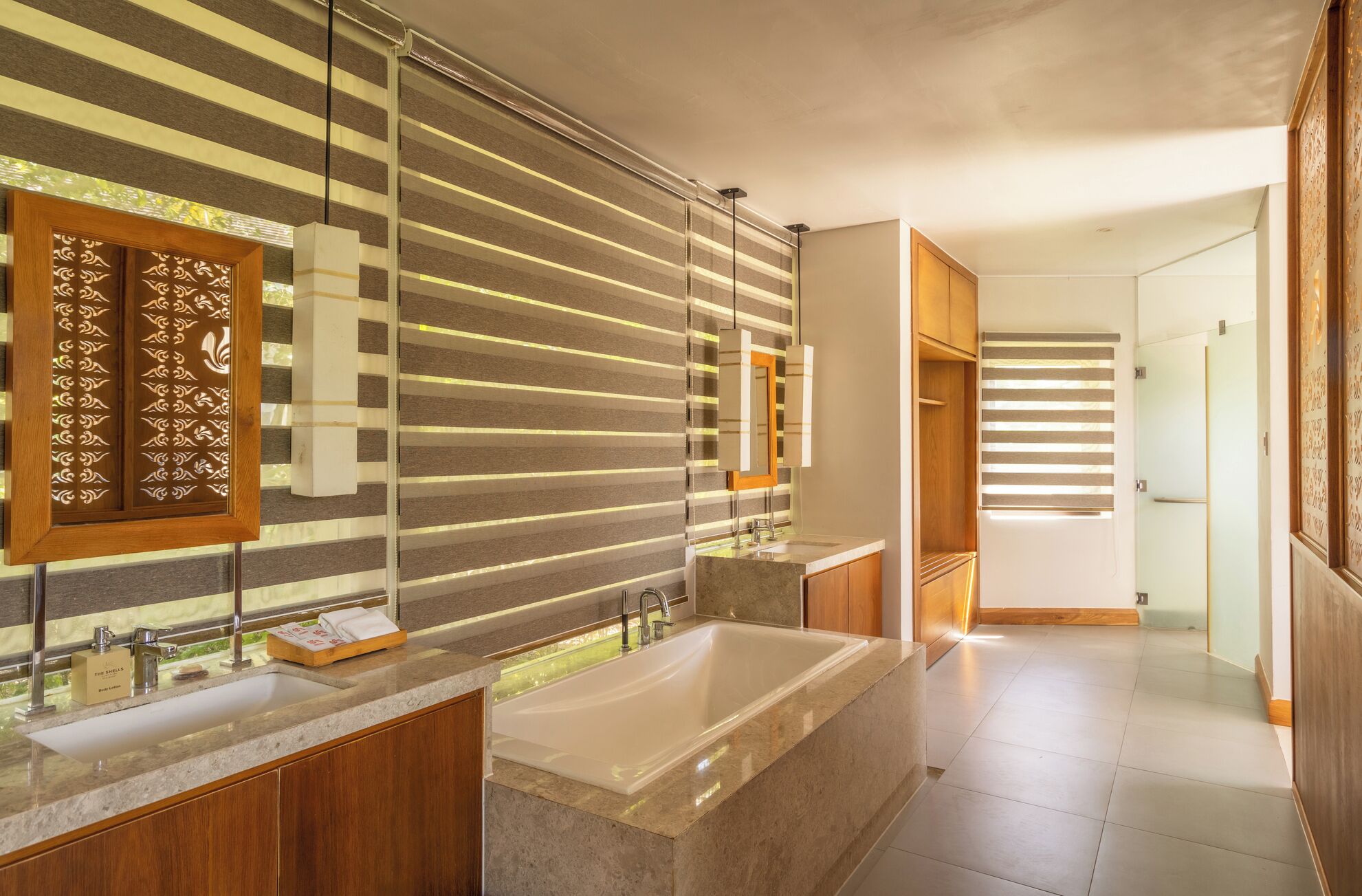 Un baño moderno con una bañera grande, dos lavamanos y un tocador.