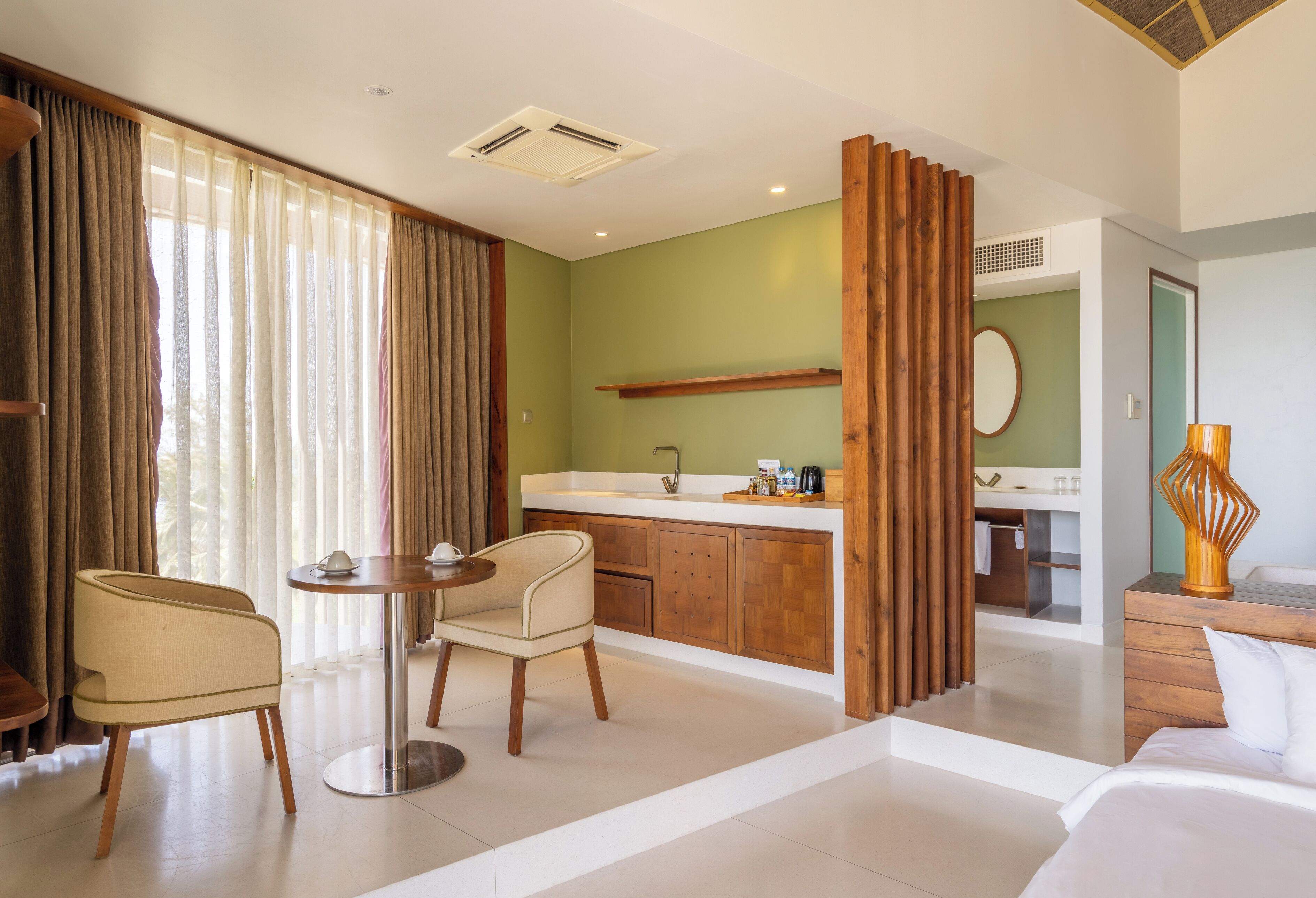 A hotel room with a dining area, a kitchen, and a bathroom.