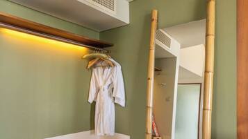 A bathroom with a wooden vanity, a mirror, a towel rack, and a chair.