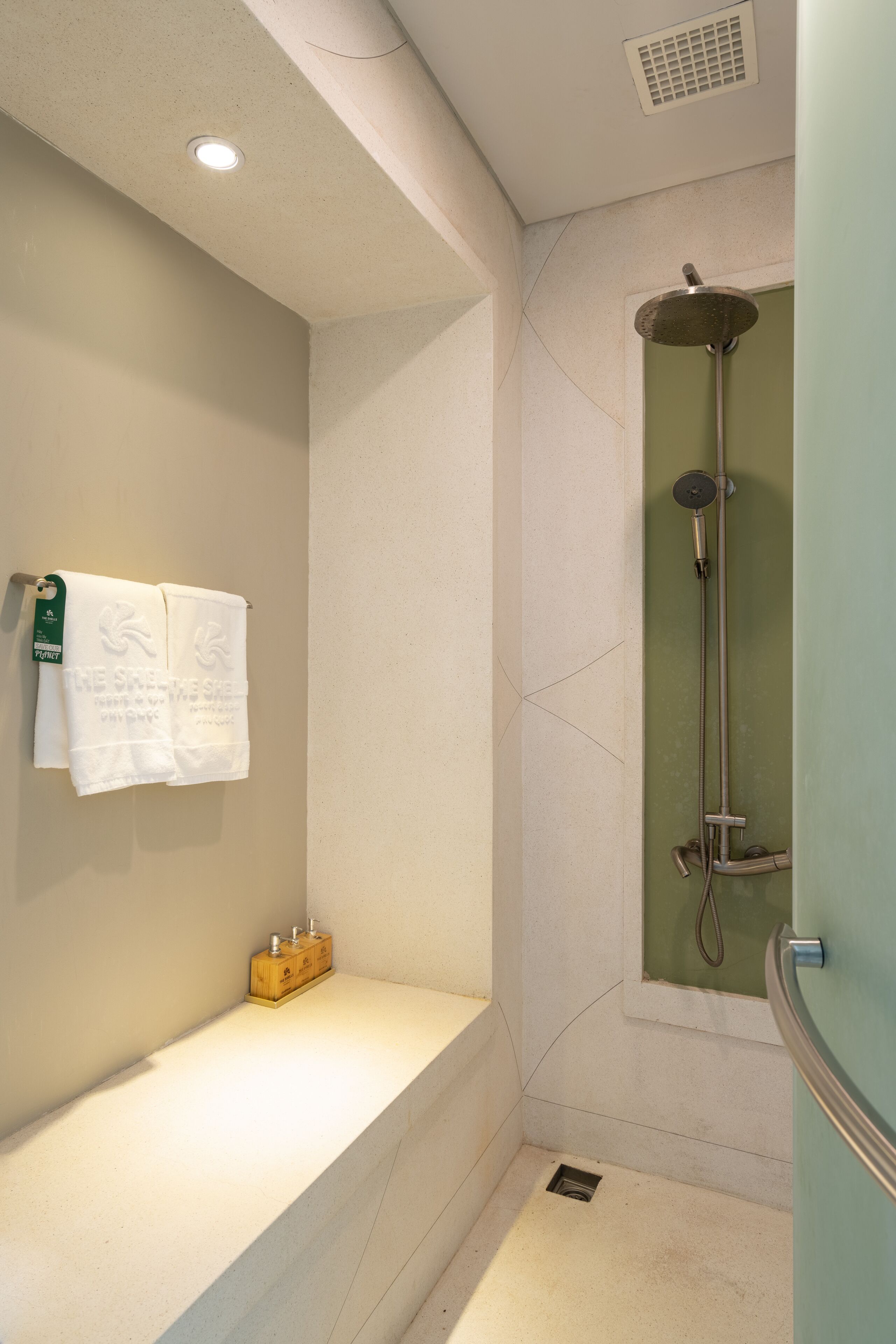 A bathroom with a bathtub, a shower, and a towel rack with towels.