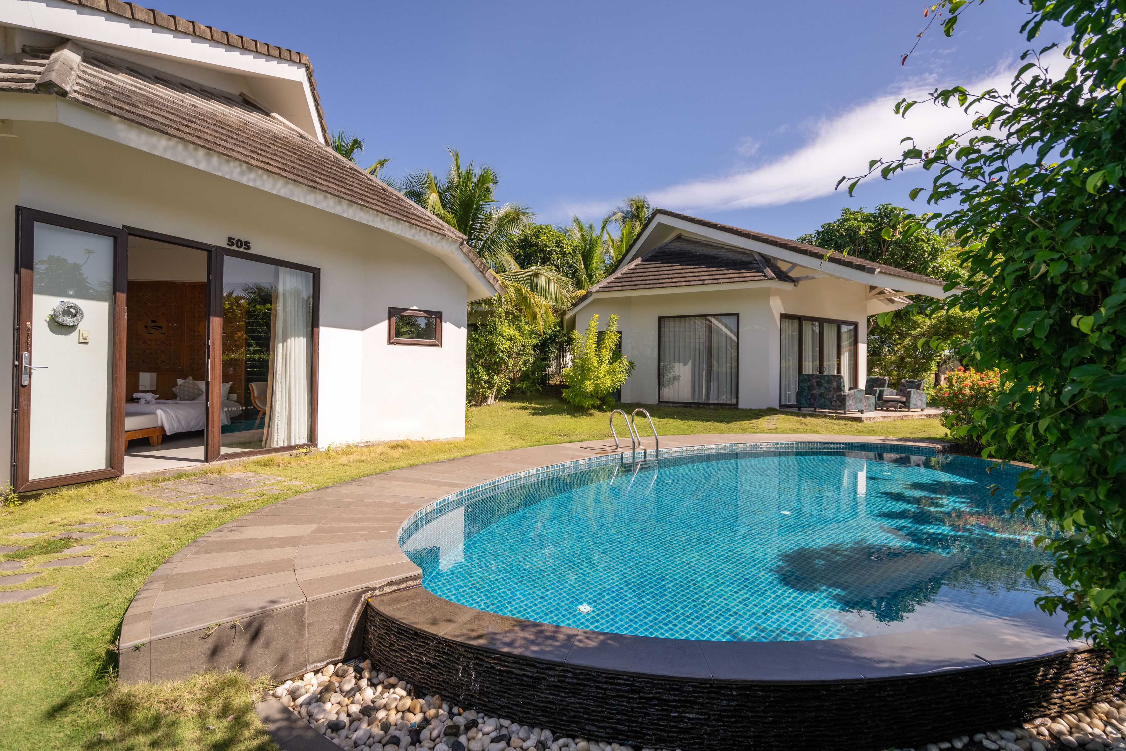Une maison moderne dotée d’une piscine, d’une terrasse et d’un jardin.
