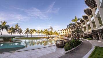 Una piscina al aire libre, sombrillas, sillones reclinables de piscina
