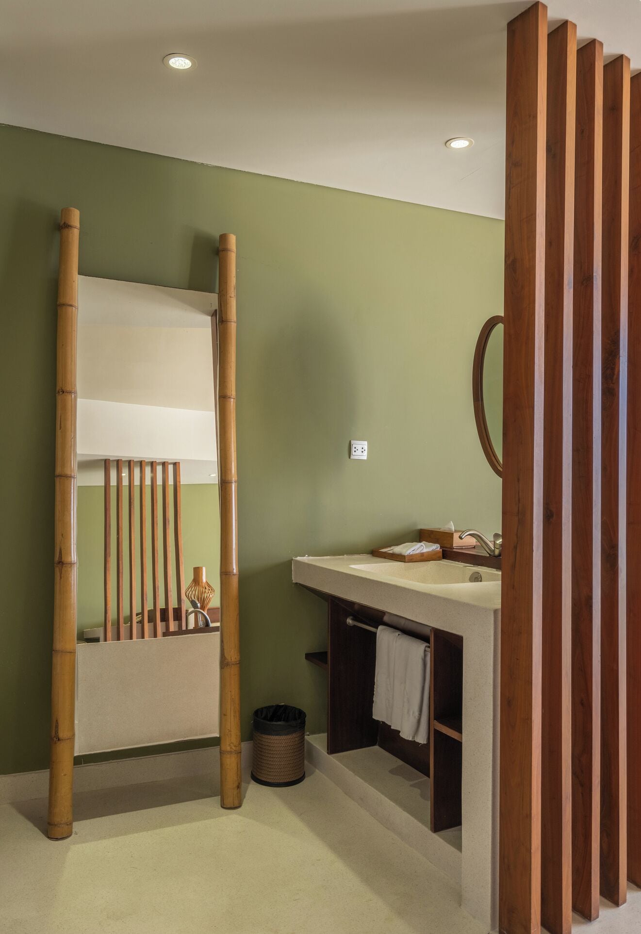 A bathroom with a bunk bed, a sink, and a mirror.