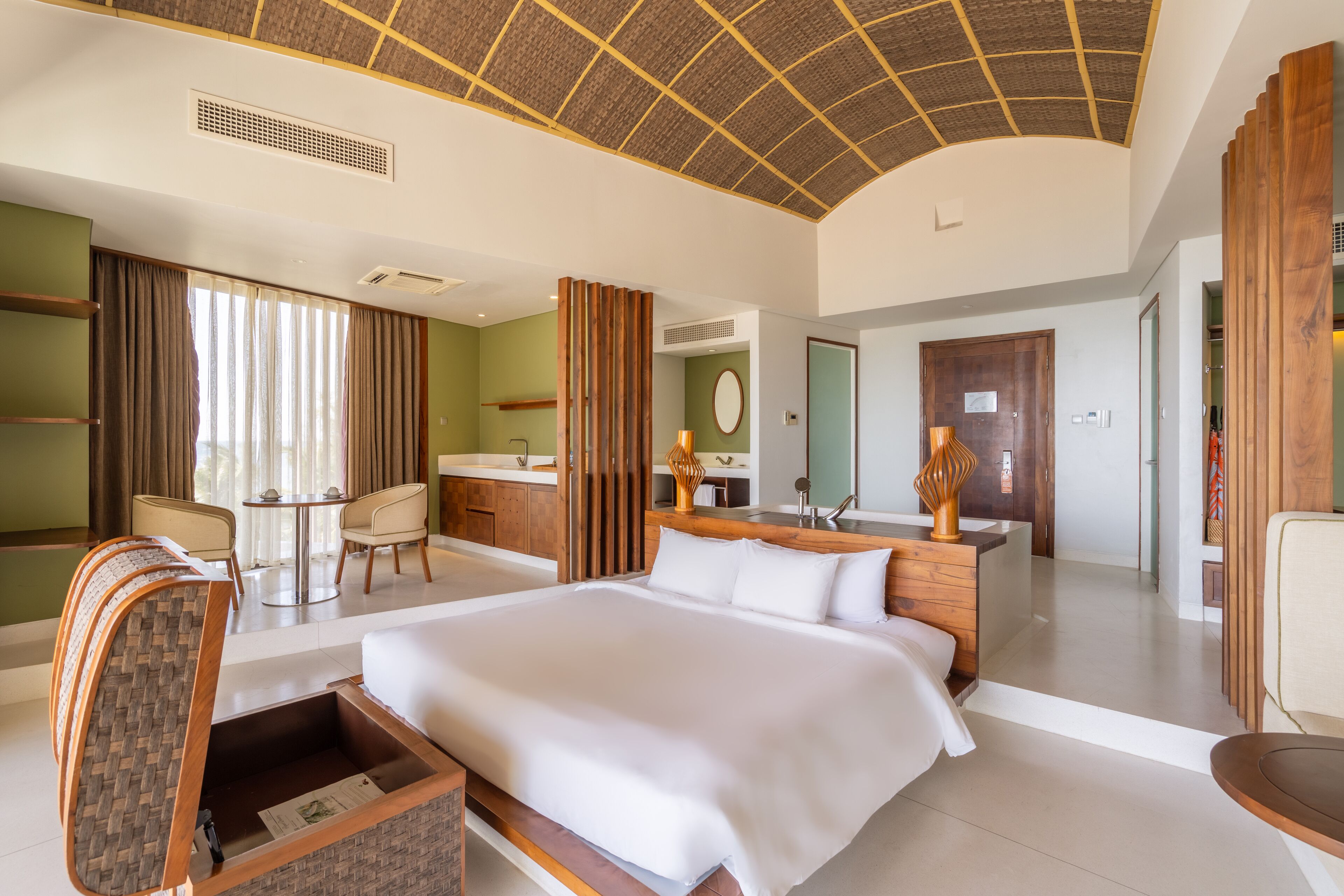 Une chambre d’hôtel avec un grand lit, un bureau, une chaise, une petite table et une salle de bain.