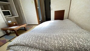 A hotel room with a bed, a wooden desk, and a television. - Asakusa Ryokan Toukaisou (Tokyo)
