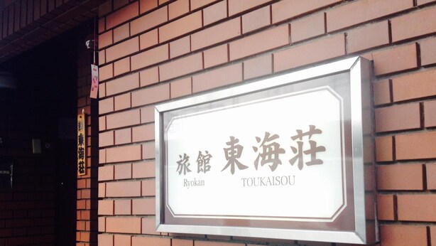 A sign for Ryokan Toukaisou, a traditional Japanese inn, mounted on a brick wall. - Asakusa Ryokan Toukaisou (Tokyo)