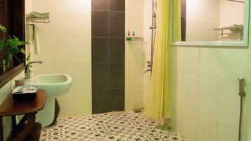 A bathroom with a shower, toilet, and sink.