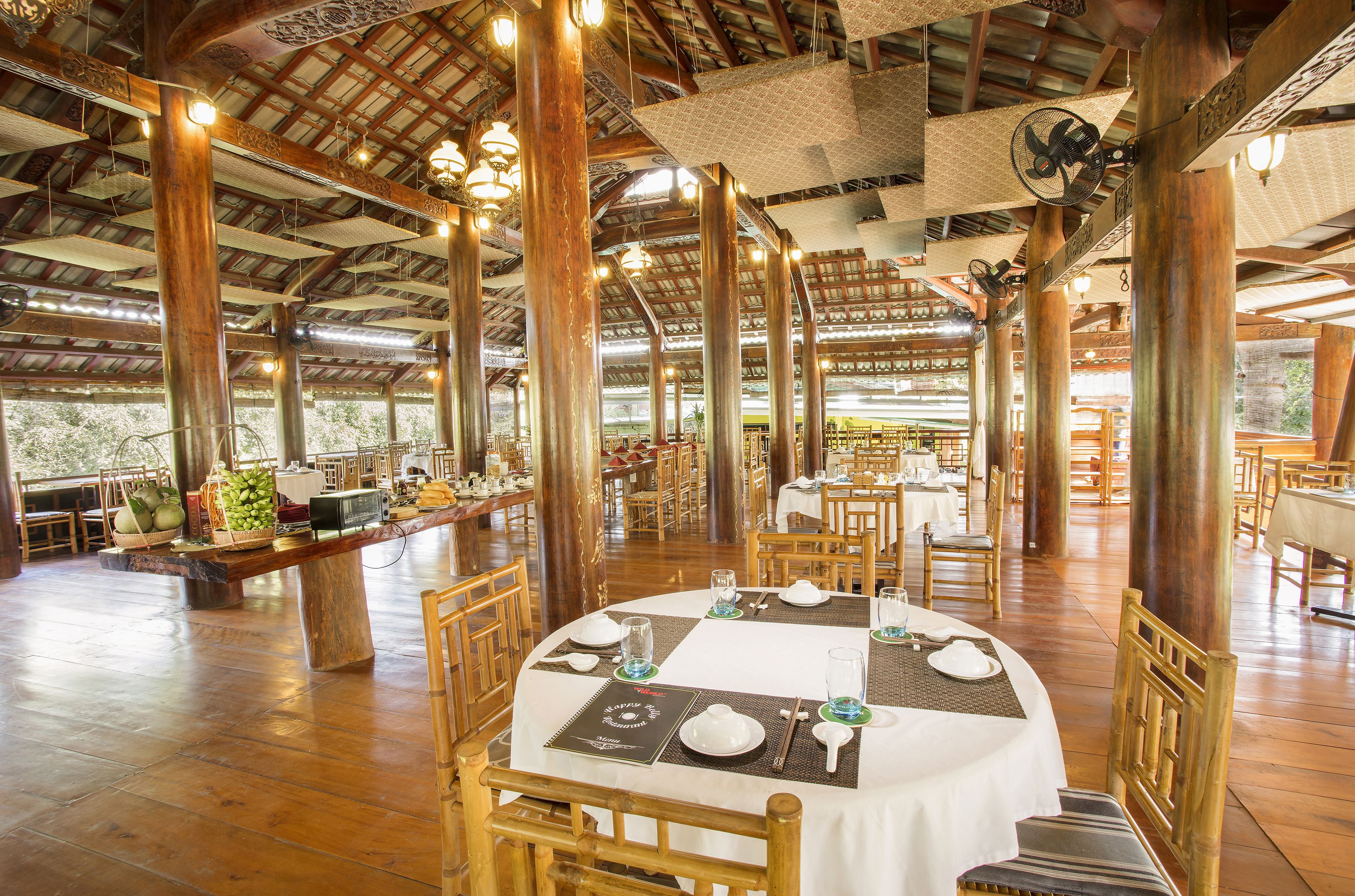Un'ampia sala ristorante con travi in legno e tavoli apparecchiati per la cena.