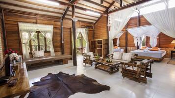 A rustic wooden room with a large leather rug, wooden furniture, and a bed with a canopy.