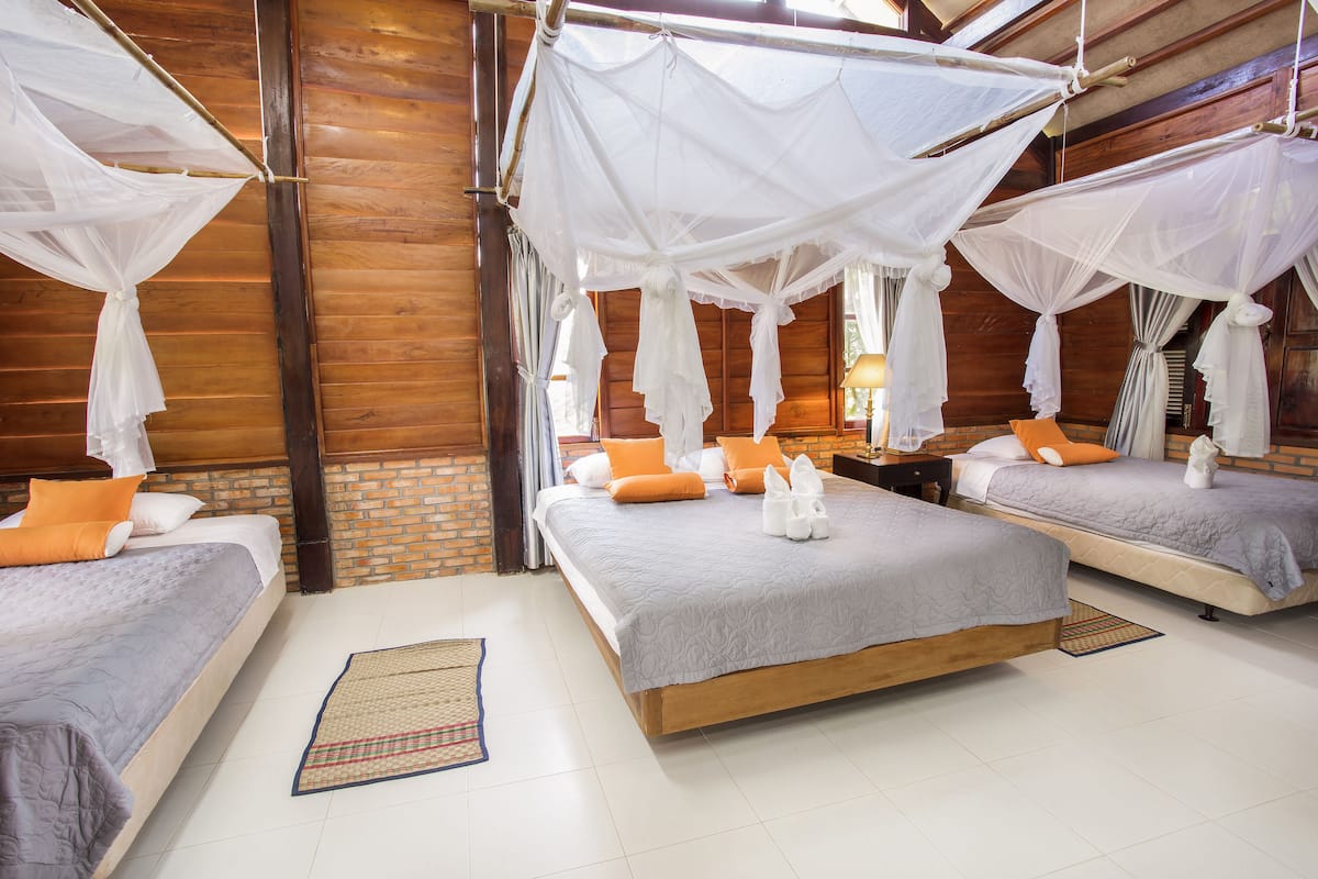 A room with two beds, each with a canopy bedspread and pillows.