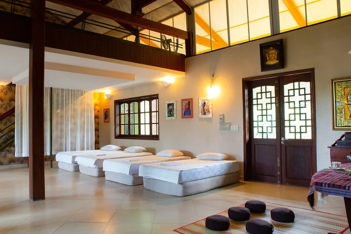 A hotel room with a lofted sleeping area, a staircase, and a traditional door with a geometric pattern.