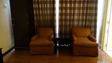 A room with two armchairs, a small table, and a wardrobe.