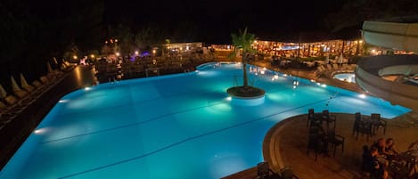 Una piscina al aire libre de temporada, sombrillas, tumbonas