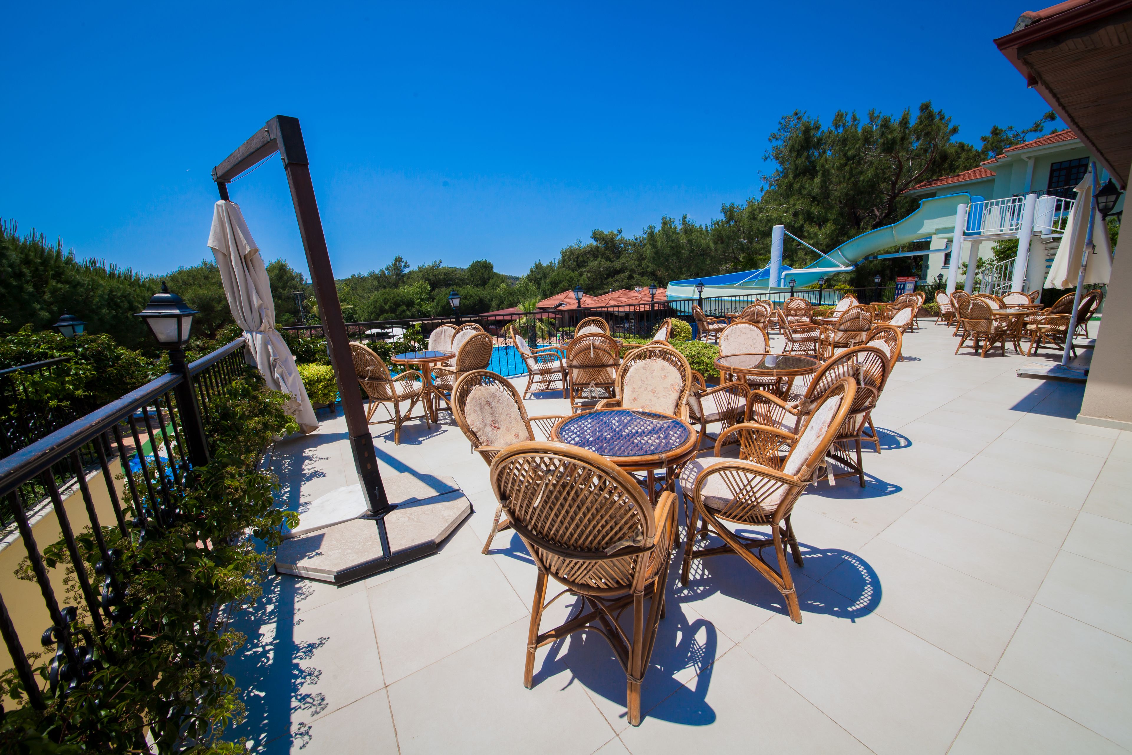 An outdoor patio with wicker furniture and a pool slide.