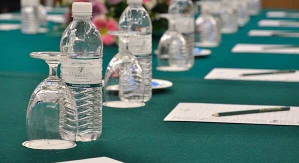A table with water bottles and papers, likely for a meeting or event.