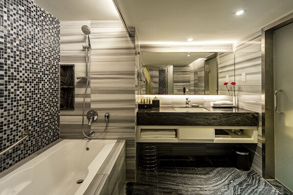 A modern bathroom with a large bathtub, a shower, and a vanity with a mirror. - Promenade Hotel Kota Kinabalu (Kota Kinabalu)
