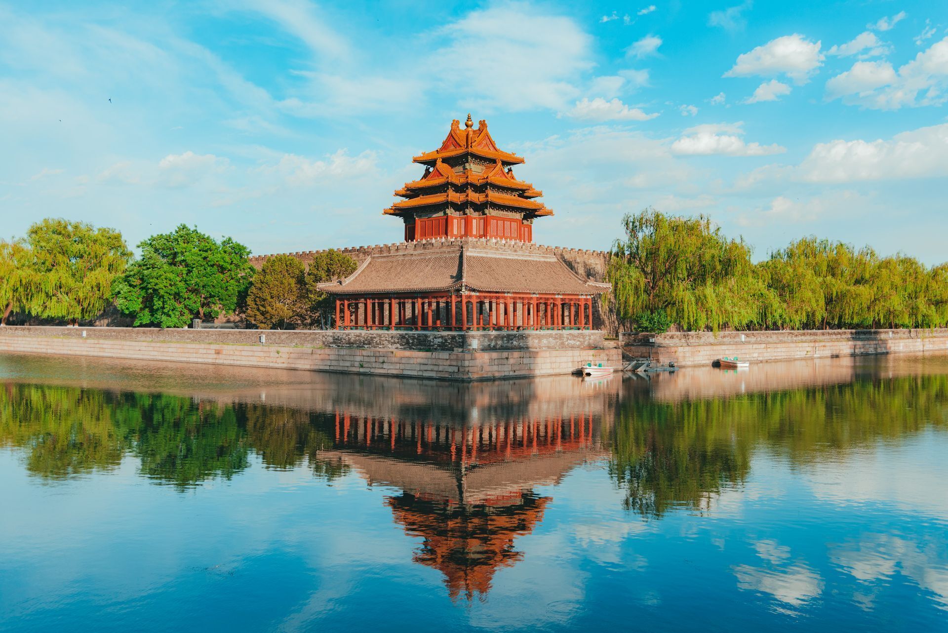 A traditional Chinese pagoda with multiple tiers, surrounded by a calm body of water reflecting the structure.